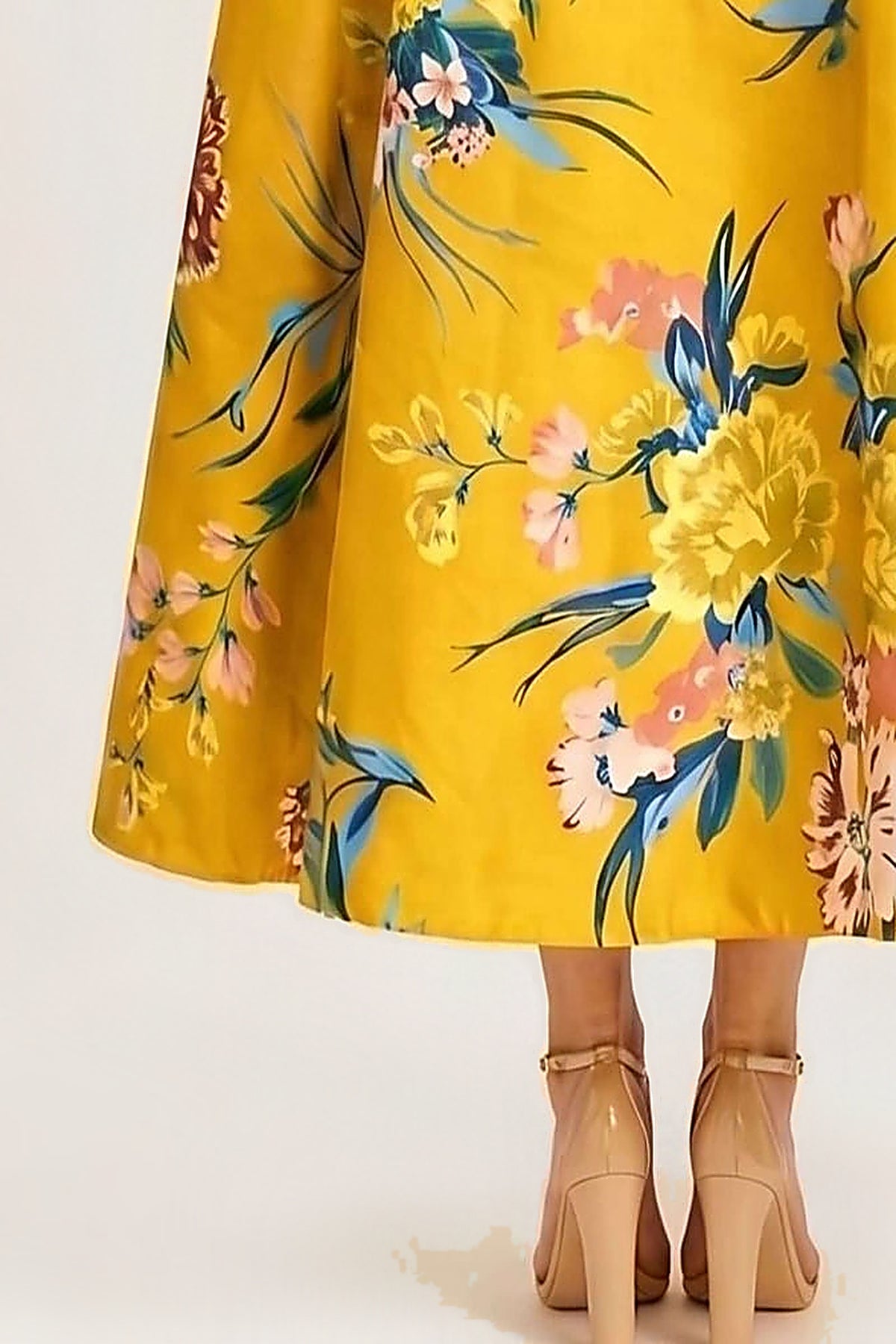 Close-up of the Golden Garden dress skirt and hem, showing the painterly blue, pink and cream floral print on golden-yellow taffeta.