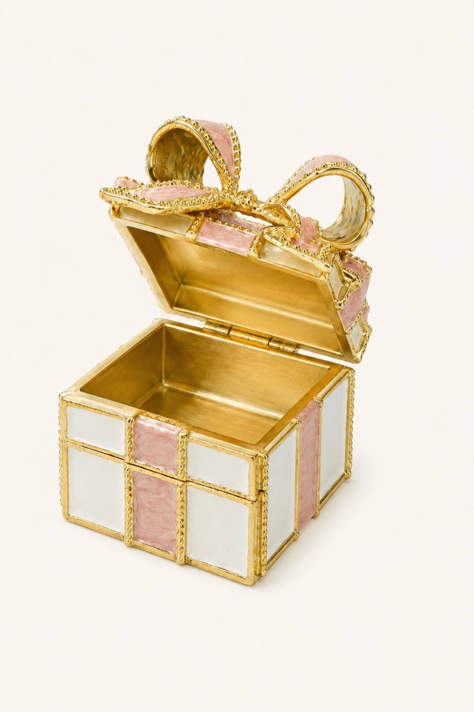 A small decorative gift box in gold-tone metal with pink and white enamel panels, shown open on a plain light background.