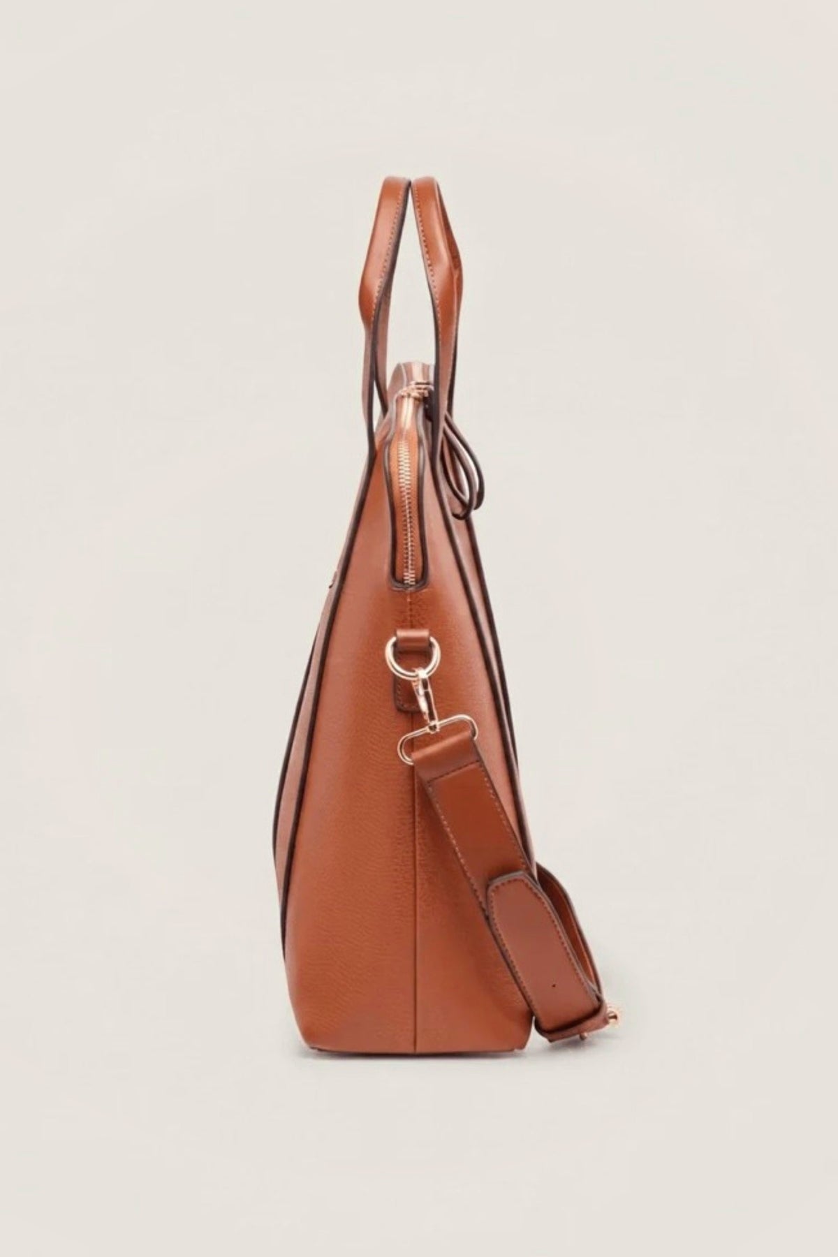 The tan Rhodes Laptop Bag from the side with its strap clipped on.