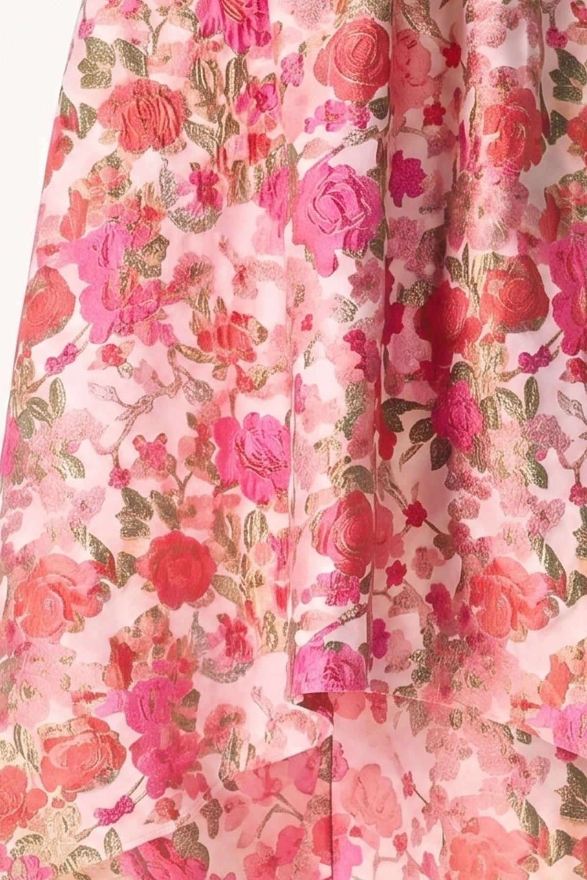 A close-up of a pink floral fabric with a metallic gold sheen, featuring roses and leaves in shades of pink, red, and gold.