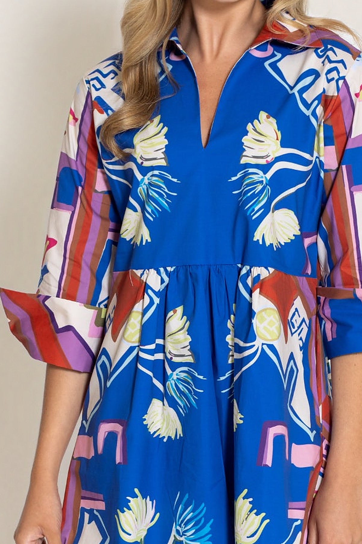 Close-up of the Sapphire Blythe Empire Dress Short showing the shirt collar, V-neckline, empire waist and cuffed three-quarter sleeves in the Sapphire print