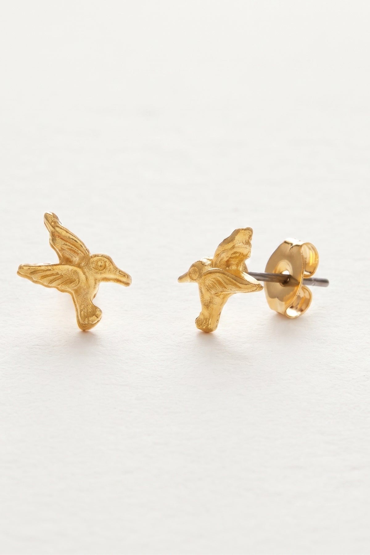 Tiny Hummingbird Stud Earrings on a cream background