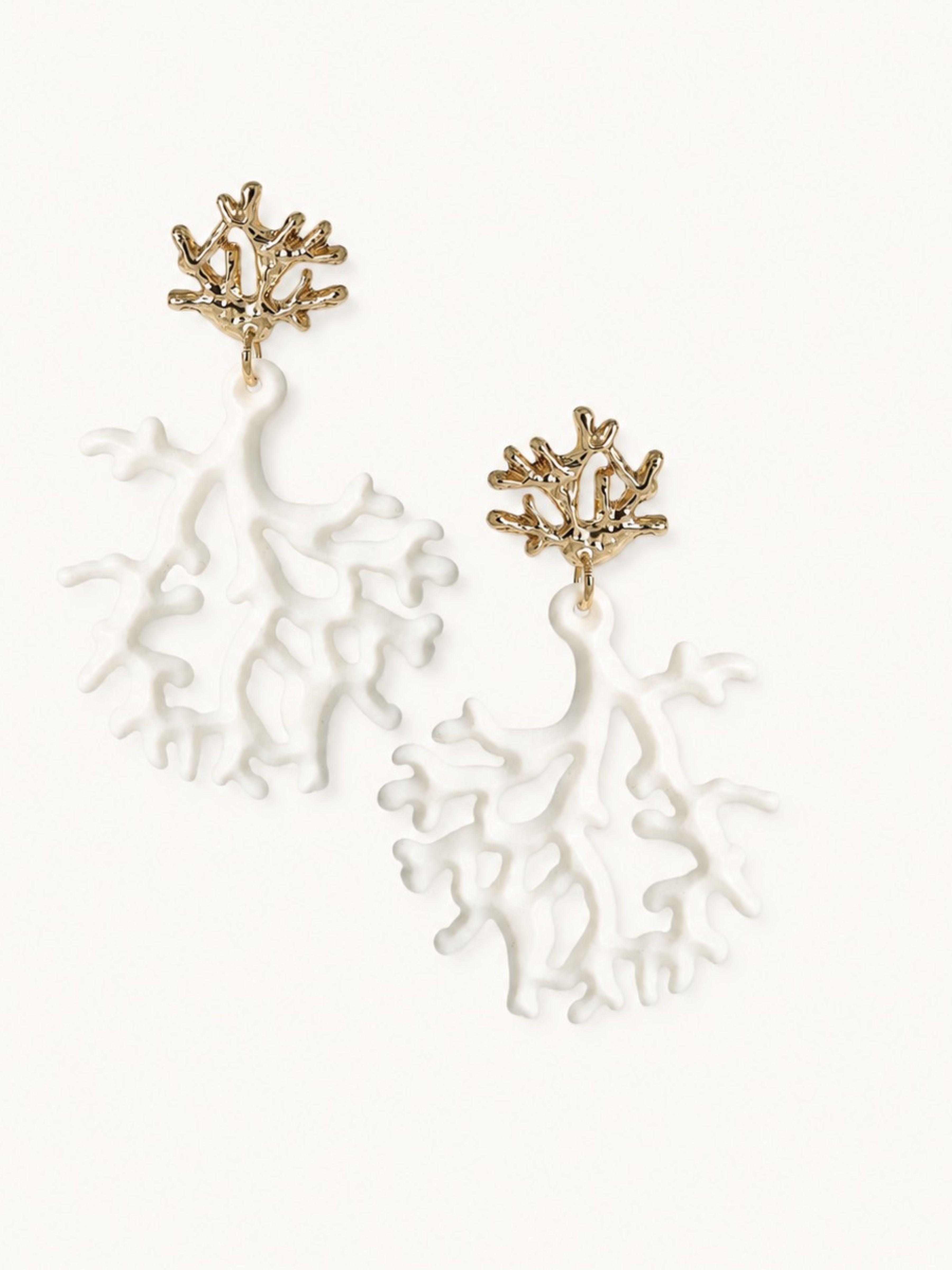 A pair of dangling earrings featuring textured gold metal studs shaped like branching coral or sea plants, with large white translucent acrylic drop pieces below, shown on a plain off-white background.